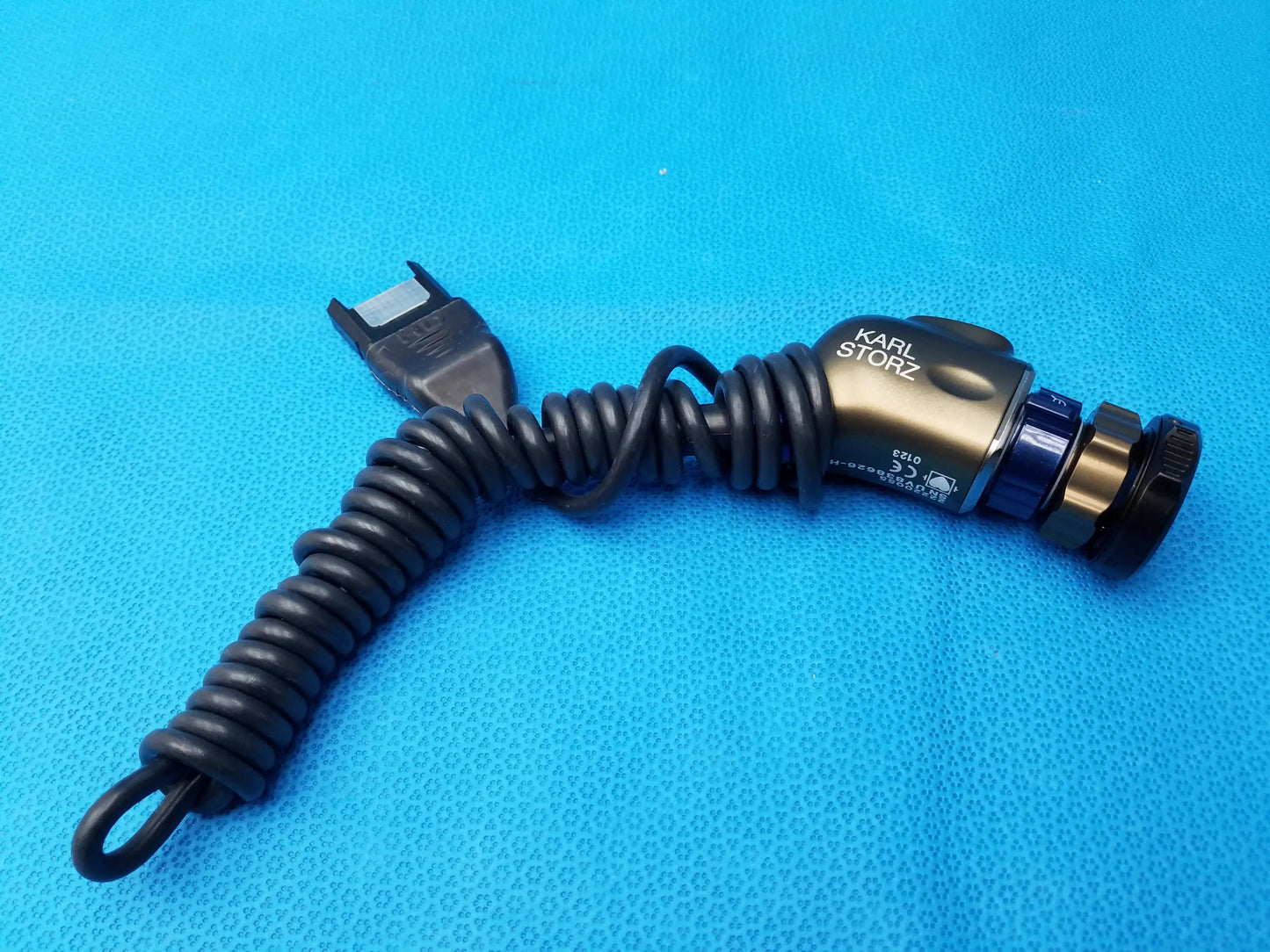 Karl Storz 22220055 camera head with coiled black cable and gold metallic body featuring blue accents precision imaging component