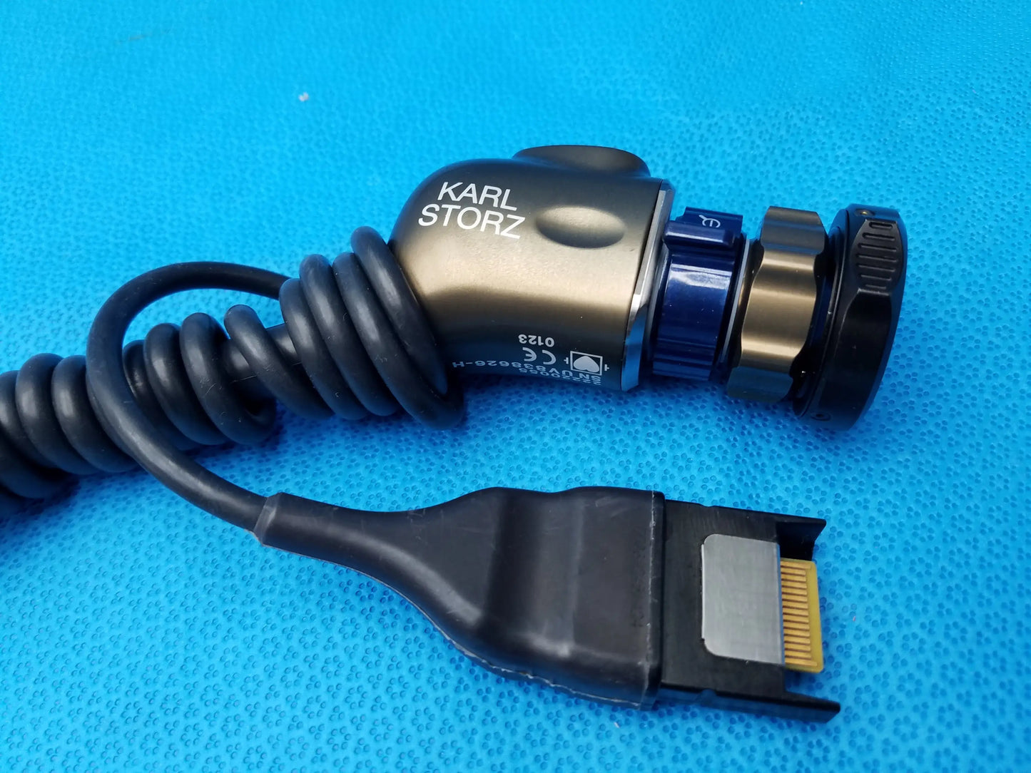 Karl storz 22220055 camera head with metallic body, black coiled cable, and blue adjustment knob for precision imaging component