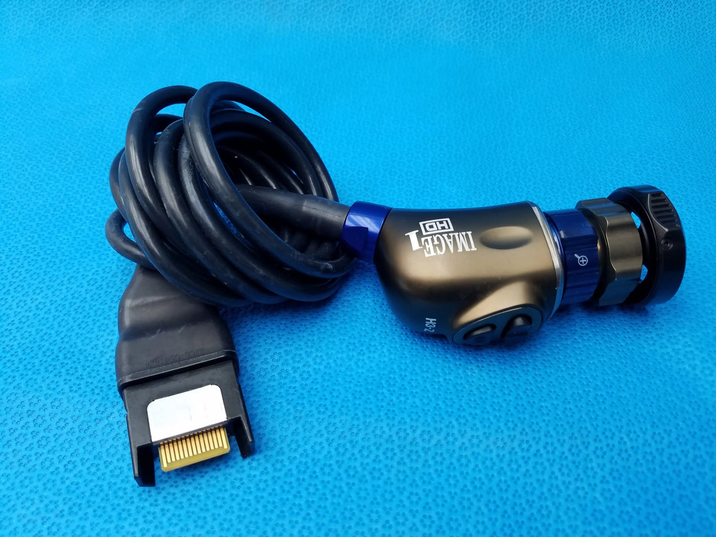 Black and blue Karl Storz camera head with gold-plated connector and coiled cable is a precision imaging component