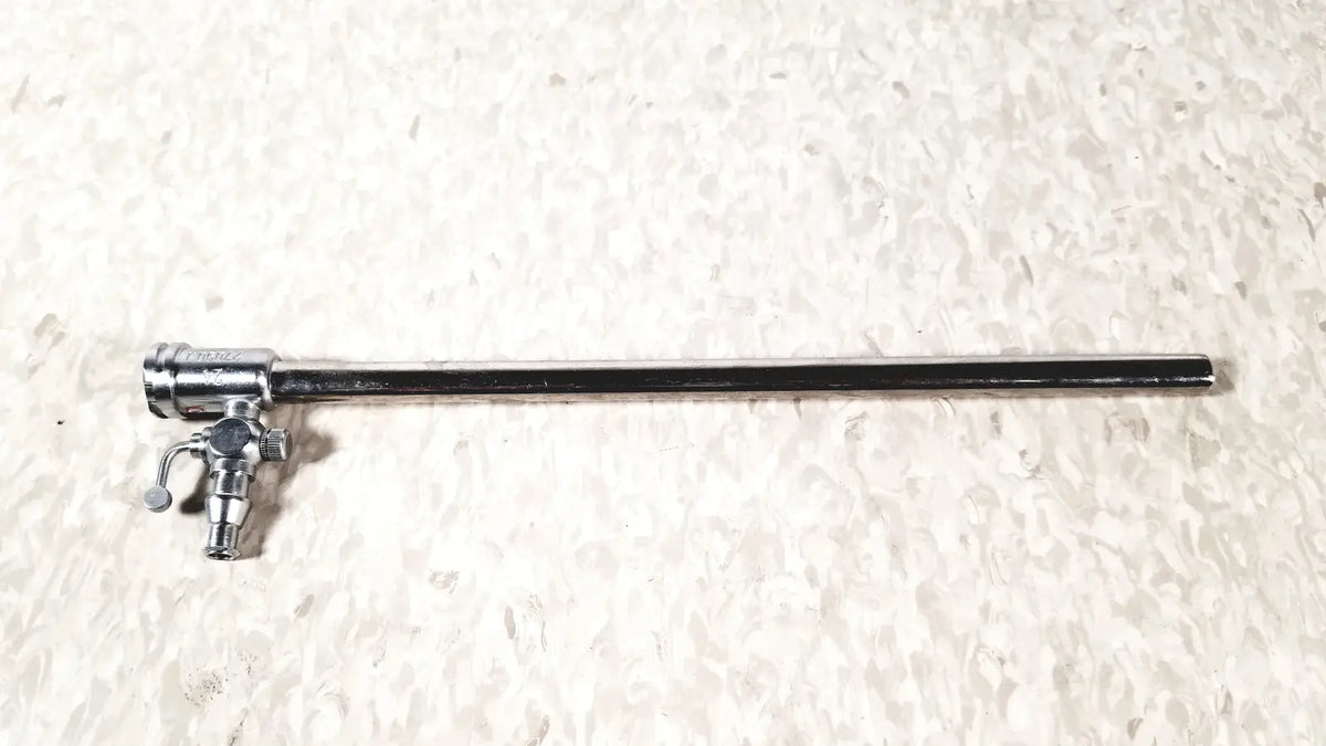 Silver-colored metal storz 27090j endoscope with long slender shaft and complex control mechanism at one end