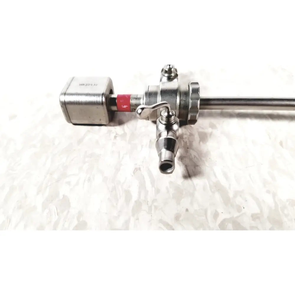 Silver-colored metallic karl storz diagnostic arthro sheath with red band and valve attachment for arthroscopy use
