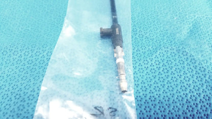 Black karl storz insulated outer tube catheter with metallic connector and printed markings resting in clear plastic bag