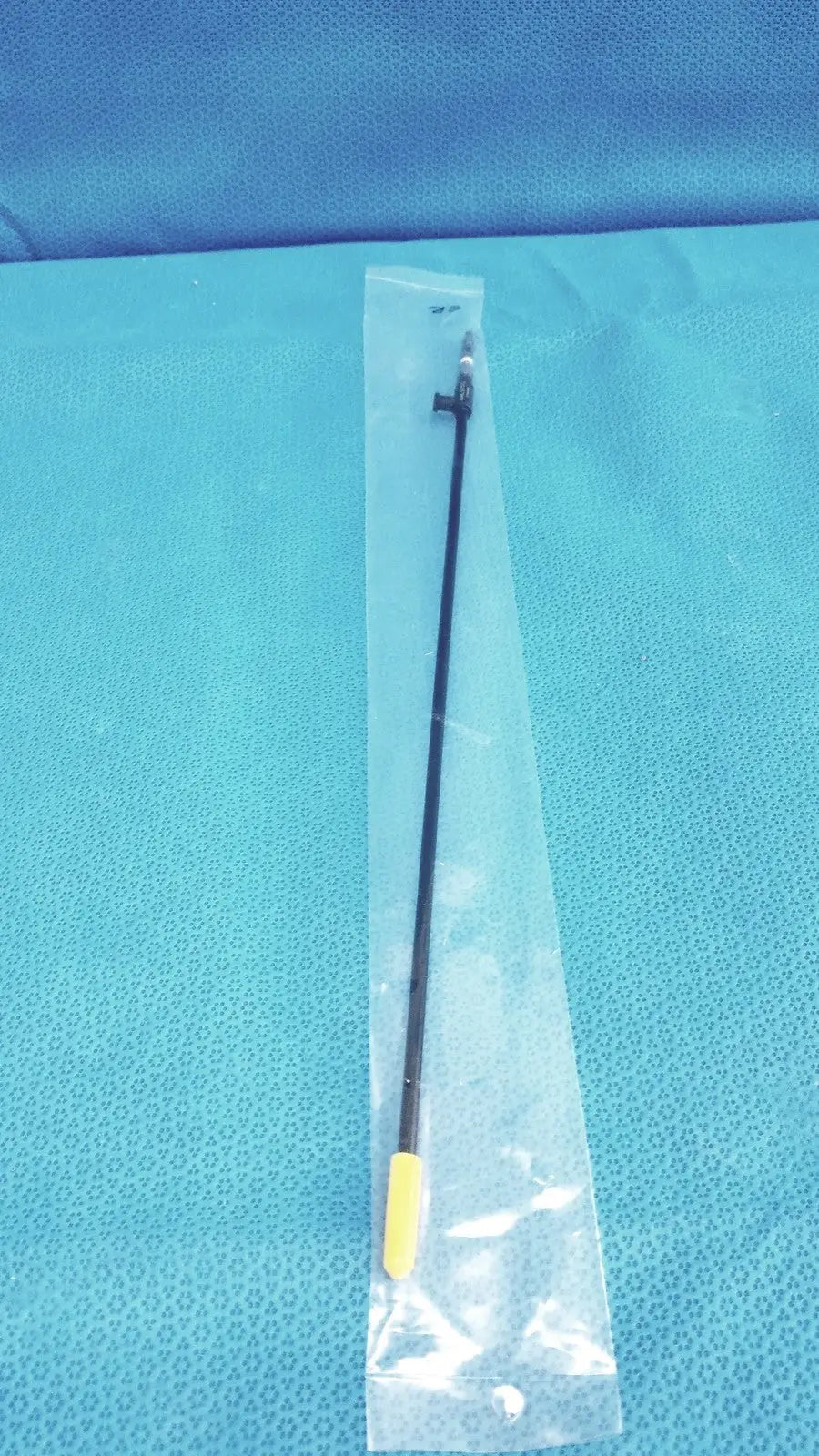Black karl storz insulated outer tube surgical instrument with yellow tip packaged in clear plastic for medical use