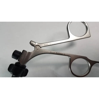 Silver surgical forceps with black rubberized handles branded karl storz clickline model 33131 for medical use