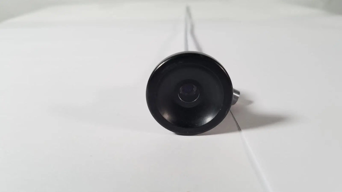 Black circular camera lens with metallic stem of karl storz hopkins 27023 a 0 degree endoscope front side view