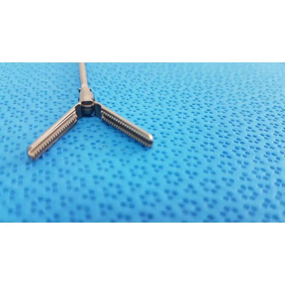Silver karl storz laparoscopic grasper model 33410 DYD with three-prong surgical retractor and textured grip surfaces