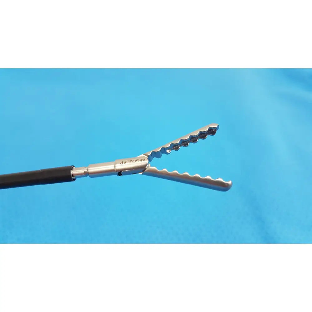 Silver surgical forceps with serrated wavy jaws and black handle in karl storz laparoscopic sheath model 33400