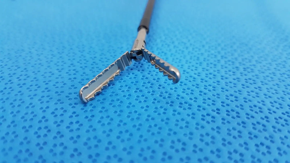 Silver karl storz laparoscopic sheath model 33400 with textured serrated jaws and black handle for surgical use