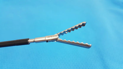 Silver surgical forceps with serrated wavy jaws and black handle in karl storz laparoscopic sheath model 33400