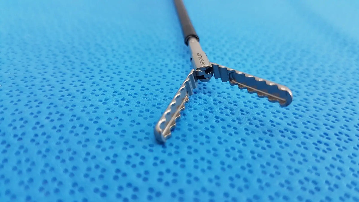 Silver karl storz laparoscopic sheath model 33400 with black handle and serrated interlocking jaws for surgical use