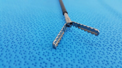 Silver karl storz laparoscopic sheath model 33400 with black handle and serrated interlocking jaws for surgical use