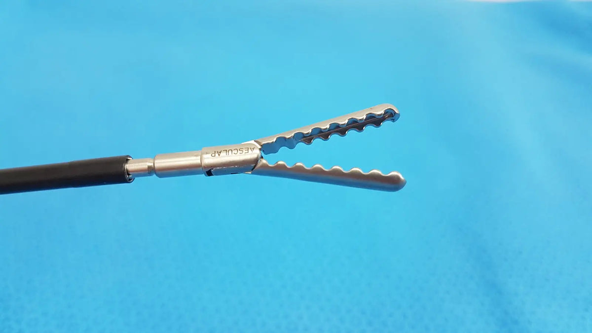 Silver karl storz laparoscopic sheath model 33400 with serrated jaws black handle branded vascular on metallic shaft