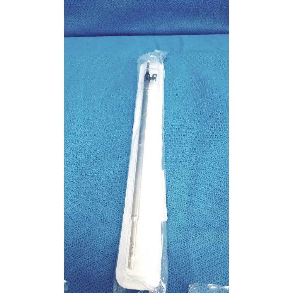 Sterile metallic karl storz ref 33500m clickline metalouter tube with sleek cylindrical body and black-tipped end in clear wrap