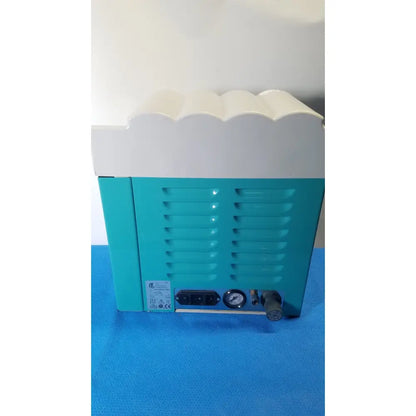 Teal and white kavo quattrocare 2104a dental handpiece maintenance unit with scalloped top edge and pressure gauge