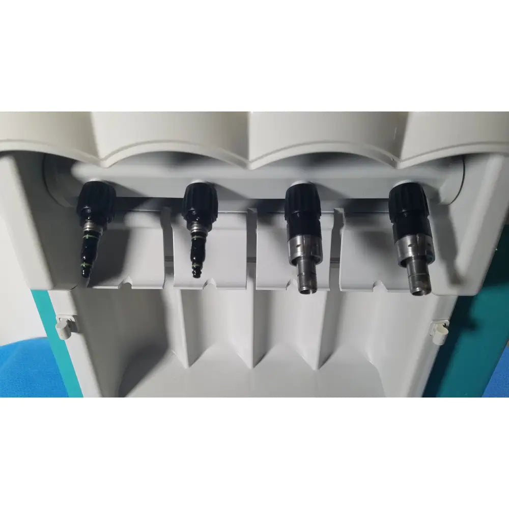 Four black and silver dental drill bits mounted in white holder for kavo quattrocare 2104a dental handpiece maintenance unit