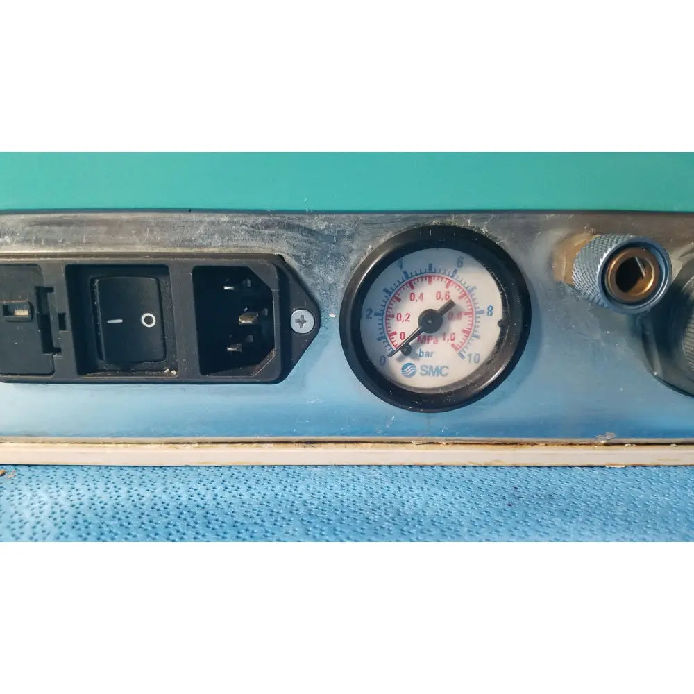 Black smc pressure gauge with white face and red markings on metallic panel of kavo quattrocare 2104a dental unit