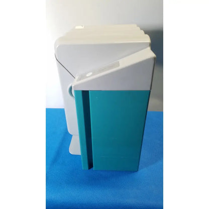 A sleek two-tone plastic kavo quattrocare 2104a dental handpiece maintenance unit with white top and teal lower section