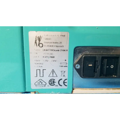 Teal industrial-grade kavo quattrocare 2104a dental handpiece maintenance unit with black power switch and specification label
