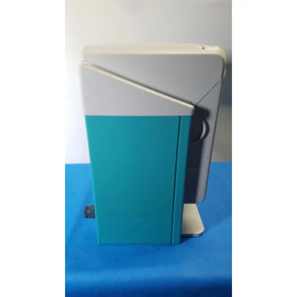 Teal and gray two-tone plastic KaVo QUATTROcare 2104a dental handpiece maintenance unit with black side cable