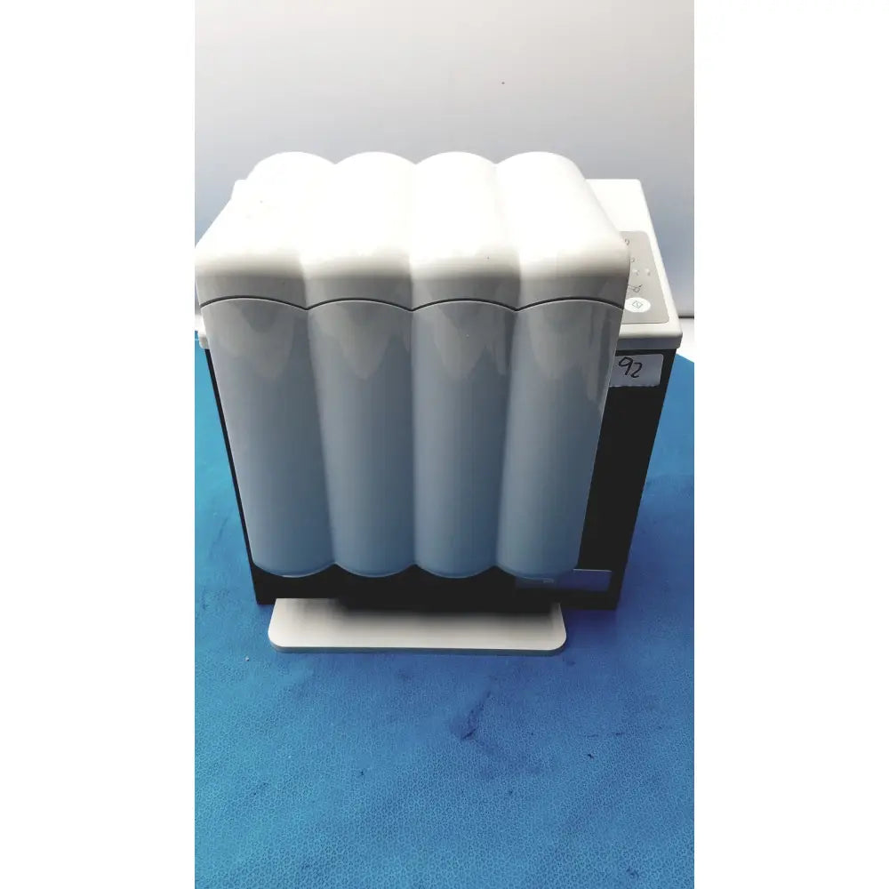 White sleek ribbed cylindrical water filters mounted on black and white base of kavo quattrocare plus handpiece system