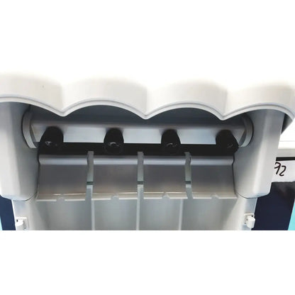White plastic kavo quattrocare plus 2124 a handpiece maintenance system with black dispensing nozzles and scalloped top edge
