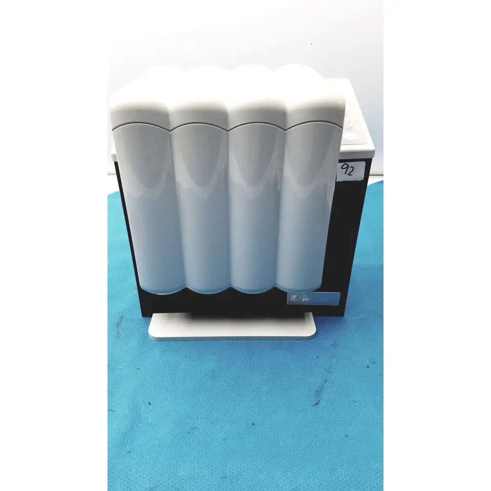 White ceramic water filter cartridge holder with four cylindrical cartridges for kavo quattrocare plus system