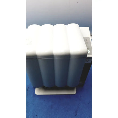 White and gray wavy-patterned paper tray with a sleek modern design in the kavo quattrocare plus handpiece maintenance system