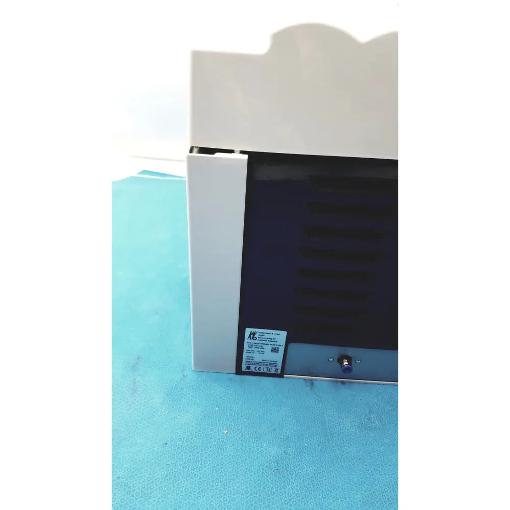 White plastic kavo quattrocare plus 2124 a handpiece maintenance system with black front panel and blue button