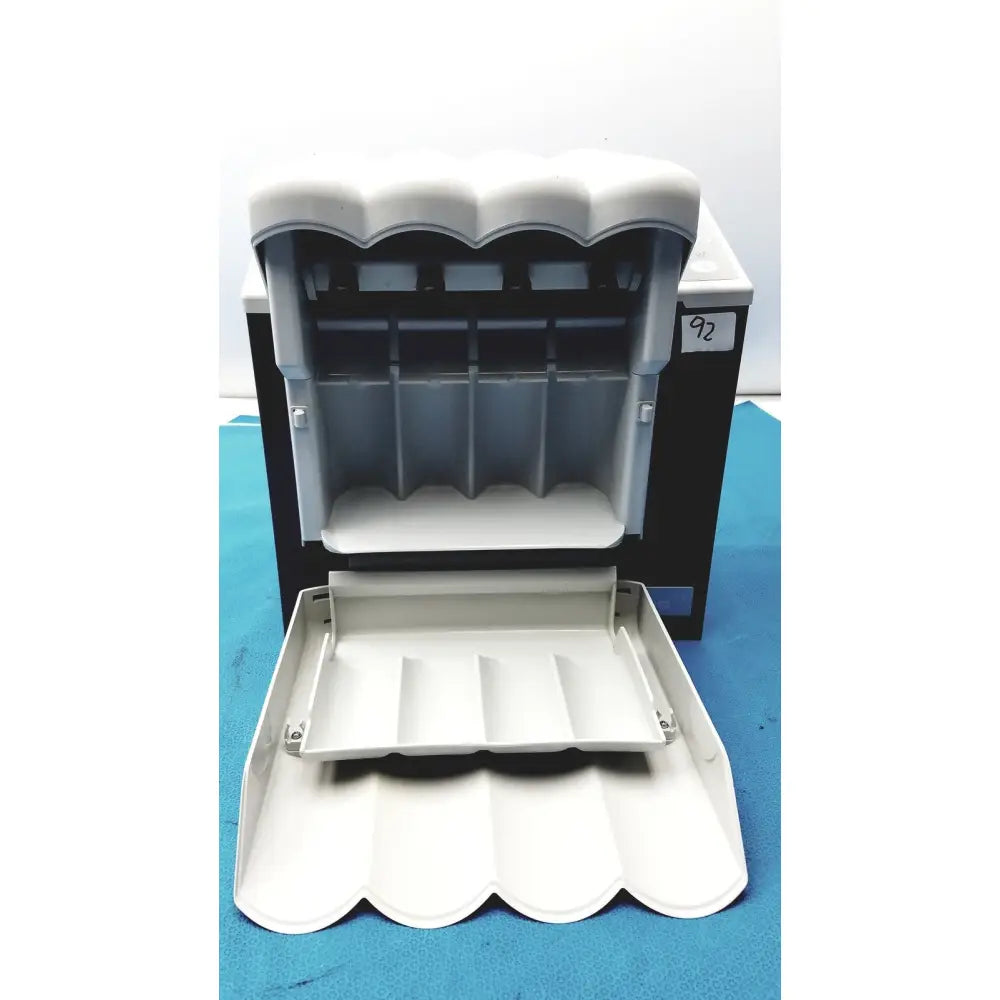 White plastic coin dispenser with scalloped top and compartments for organization in kavo quattrocare plus handpiece system