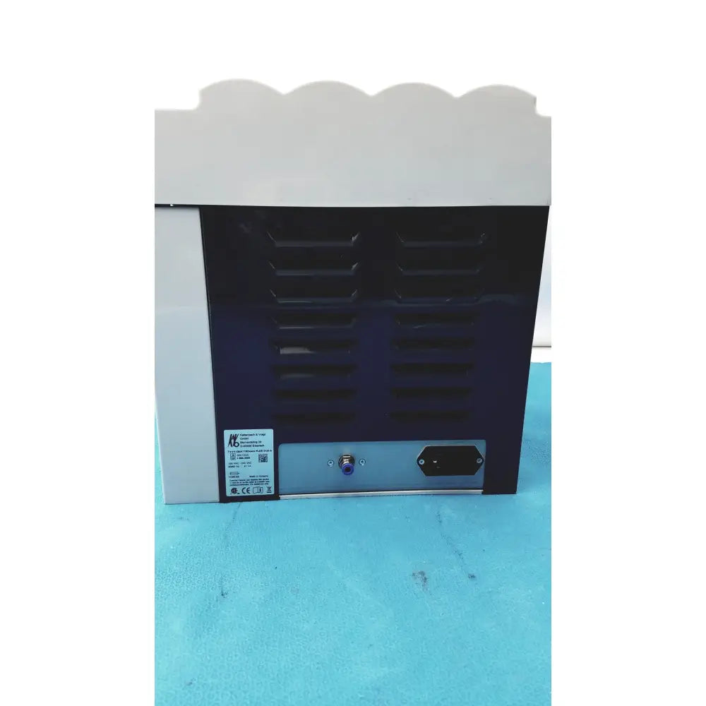 Black and white kavo quattrocare plus 2124a handpiece maintenance system back side with vented panel power socket and label
