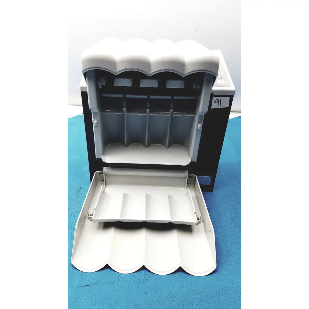 White plastic cash register with scalloped front panel and compartments in kavo quattrocare plus 2124a system