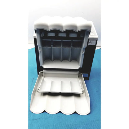 White plastic cash register with scalloped front panel and compartments in kavo quattrocare plus 2124a system