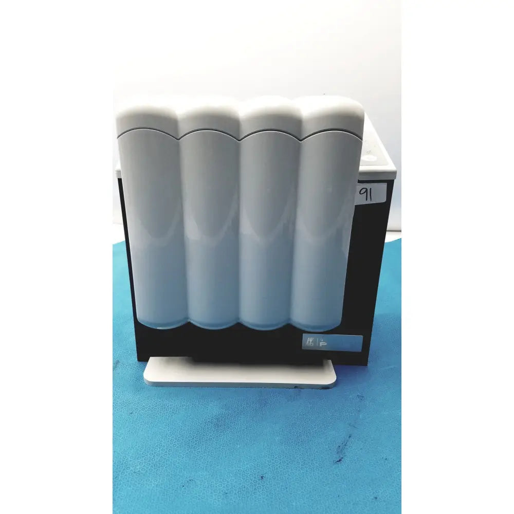 White sleek kavo quattrocare plus 2124a handpiece maintenance system with four cylindrical chambers in a row