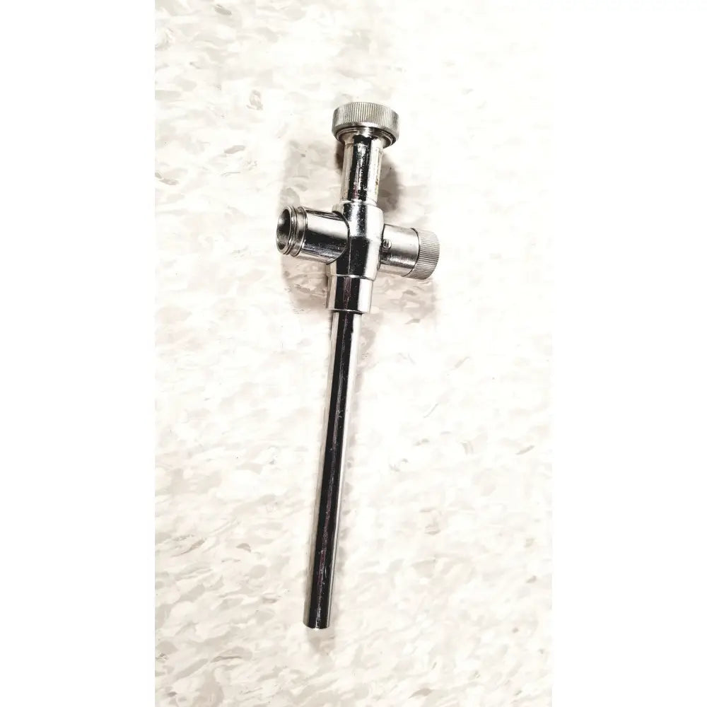 Shiny chrome-plated brass plumbing valve with cross-shaped body and threaded ends for reusable metal trocar sleeve use