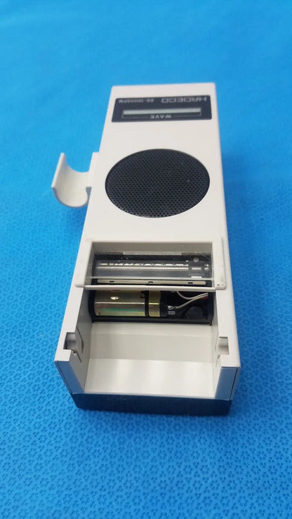 White and black portable radio with circular speaker grille labeled horo 038 from koven wave hadeco moel es-1000spm