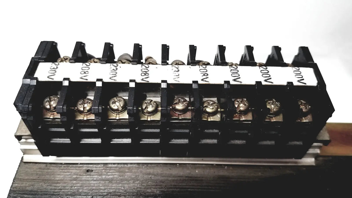 Black plastic terminal block with silver screws and voltage labels for kowa sangyo power transformers in reuse medical settings