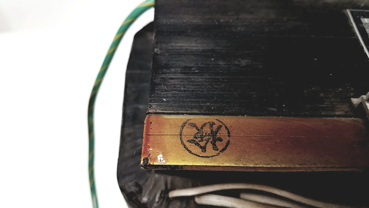 Black rectangular kowa sangyo power transformer with gold metallic strip and embossed circular logo for reuse medical use