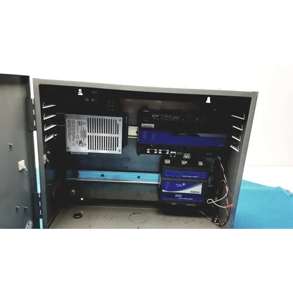 Black industrial control panel housing multiple blue-lit electronic devices with wiring in kryptonite cmt22a access system