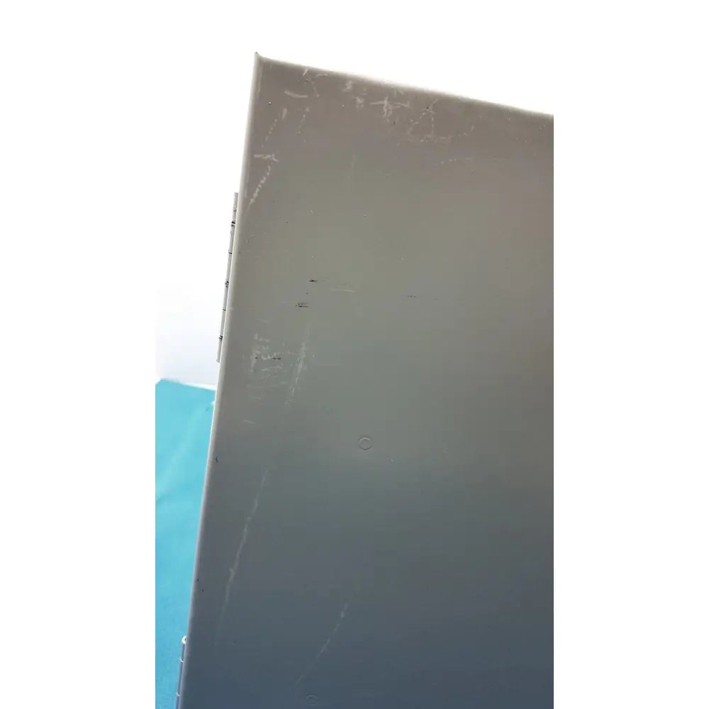 Gray metal box with scratches and a circular indentation on the back side of kryptonite cmt22a access control system