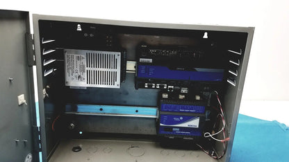 Black industrial control panel housing multiple blue-lit electronic devices with wiring in kryptonite cmt22a access system