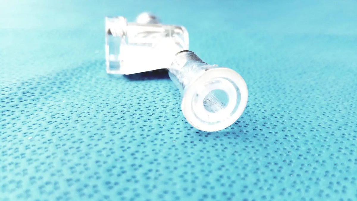 Clear plastic lab glass adapter with cylindrical body and threaded end featuring stopcock valve for precise flow control
