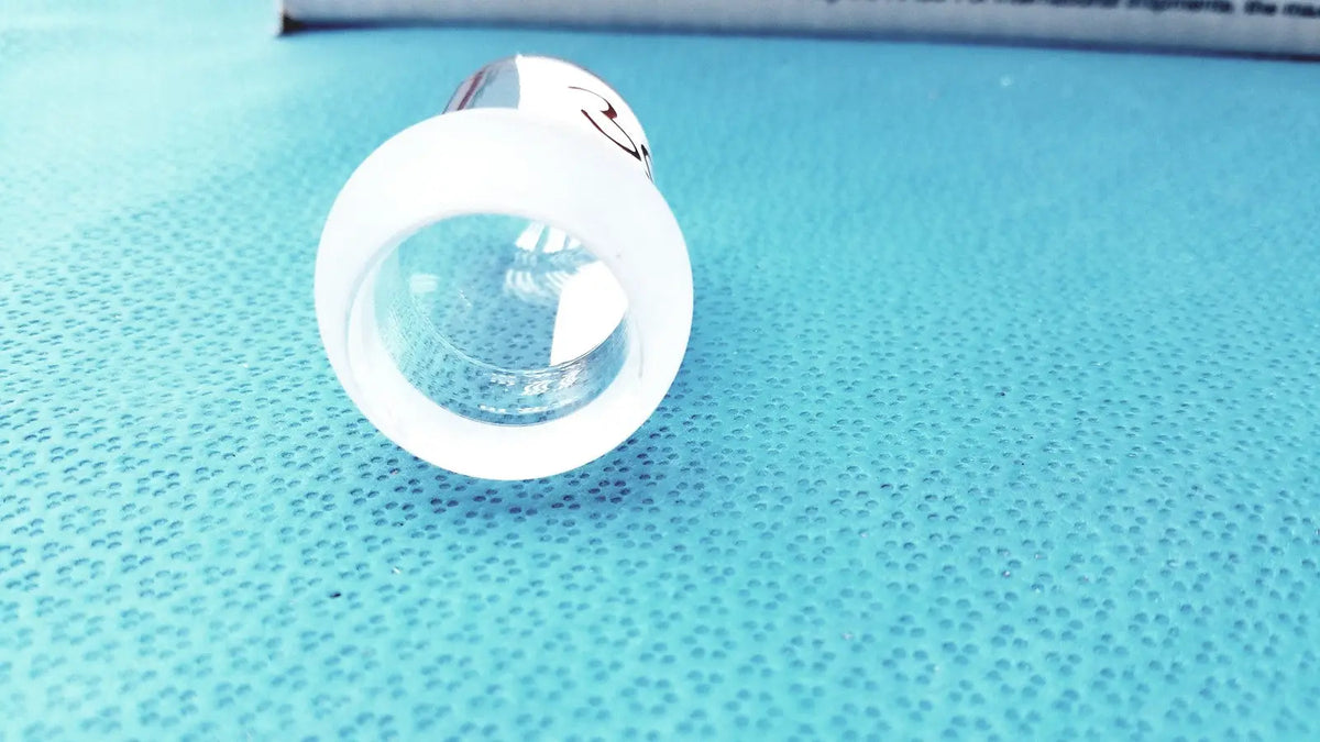 White plastic lab spherical joint lens cap with clear circular opening and small black smiley face for glass stoppers