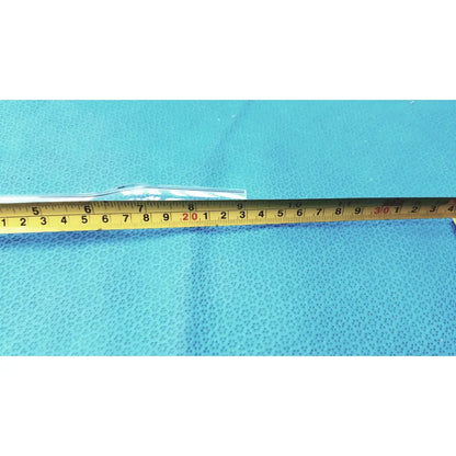 A clear transparent borosilicate laboratory glass decantor separator tube lying horizontally on a blue textured surface