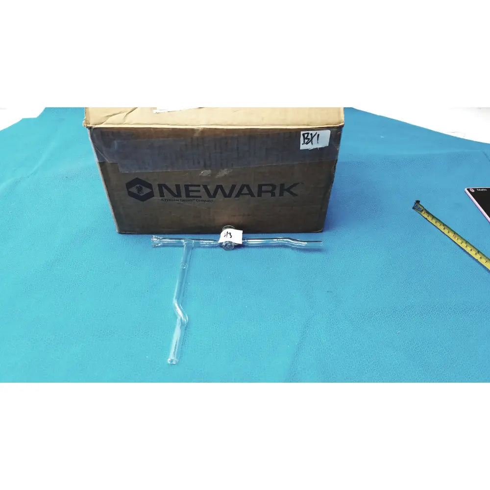 Laboratory glass decantor separator with clear t-shaped plastic tool, metallic joint, and white label for precise use