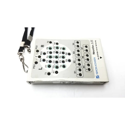 White rectangular neurofax eeg recording device with black silver labeled input ports and lanyard for laerdal compact suction unit back