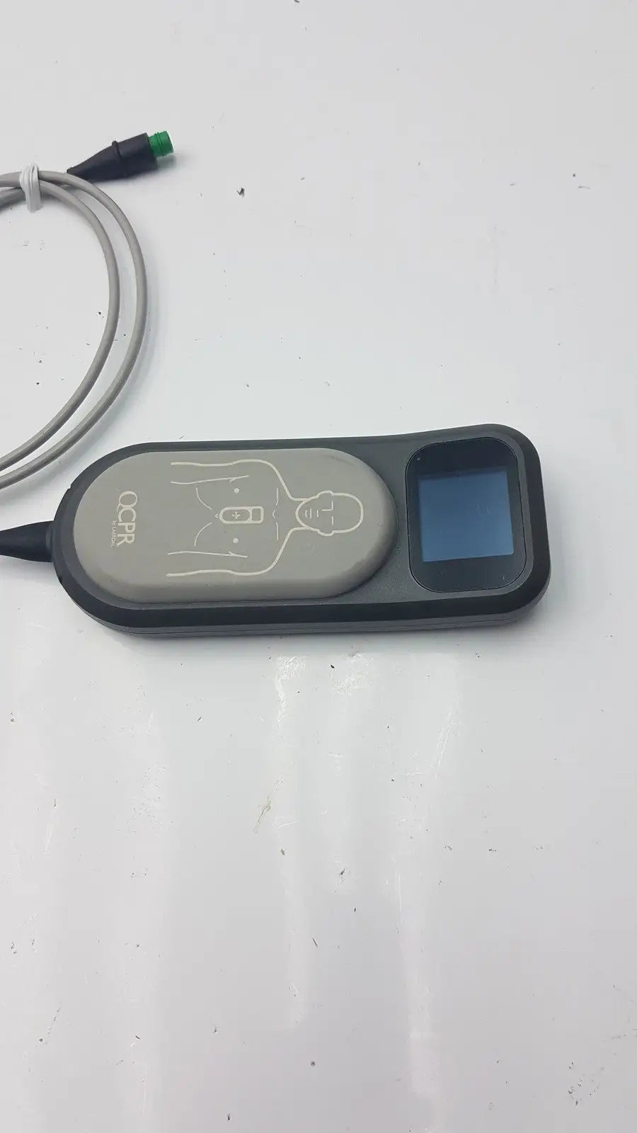 Gray and black laerdal cpr meter with small screen diagram of chest compression points and attached cables for cpr use
