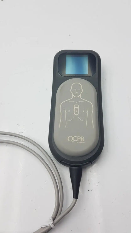 Gray and black laerdal cpr meter with small screen chest diagram and attached gray cable for emergency use