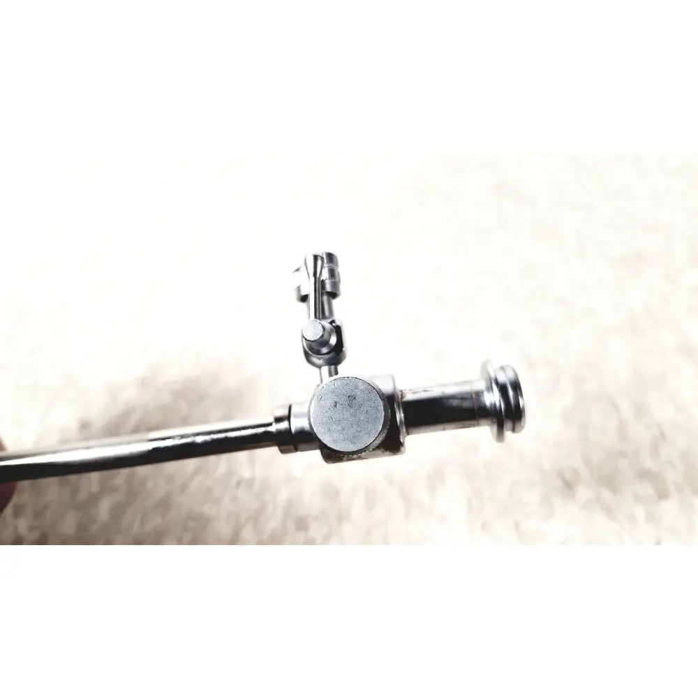 Shiny chrome-plated metal laparoscopic obturator with cylindrical handle and articulated joint for reuse medical use
