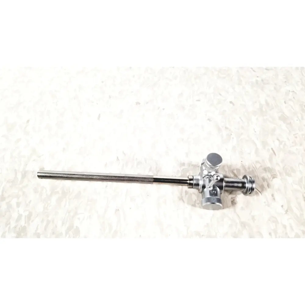 Silver-colored metal laparoscopic obturator with 5 fr instrument featuring complex valve mechanism for reuse medical procedures