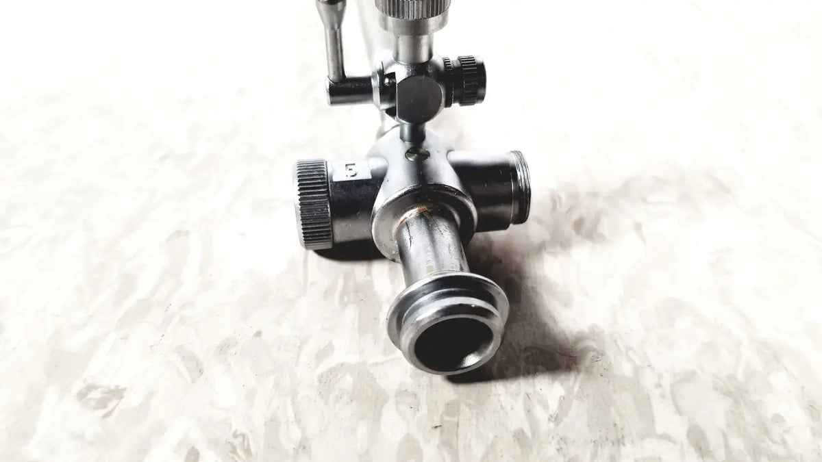 Black metal gas regulator with threaded ports and knurled knobs for laparoscopic obturator and reuse medical instruments
